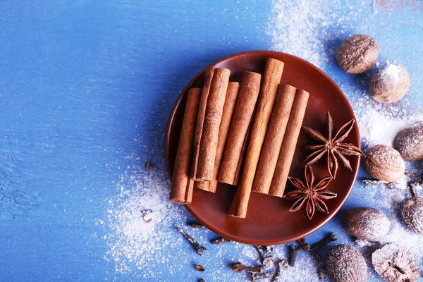 Cinnamon sticks, star anise, nutmeg and cloves on color wooden table background — Stock Photo, Image
