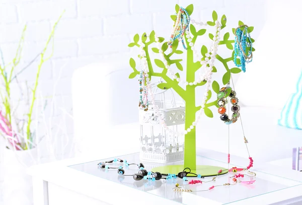 Декоративный стенд с украшениями и бижутерией на столе в номере — стоковое фото