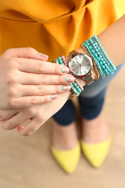 Stylish bracelets and clock on female hand top view — Stock Photo, Image