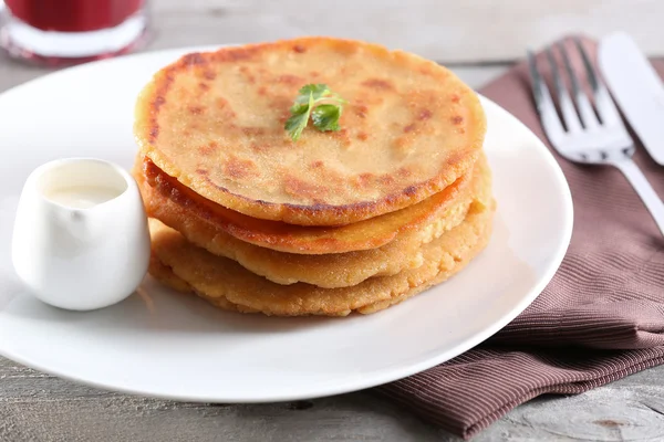 Stack of corn tortillas with stuffing and glass of juice on wooden table background — Stock Photo, Image