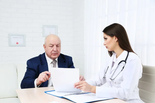 Young female doctor receiving patient in her office — Stock Photo, Image