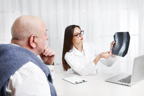 Läkarna tar emot röntgenresultat i office på vit bakgrund — Stockfoto