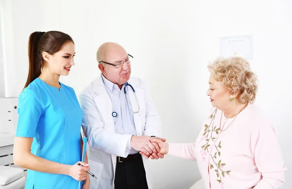 Happy doctors and patients in hospital clinic — Stock Photo, Image