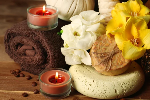 Composición de tratamiento spa, vela y flores sobre fondo de mesa de madera — Foto de Stock