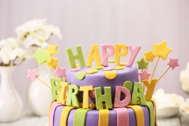 Lezzetli doğum günü pastası ışık arka plan üzerinde masada