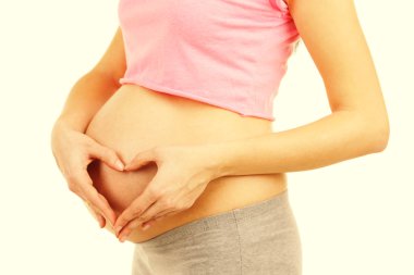 Güzel genç hamile kadının karnı üzerinde açık renkli temas