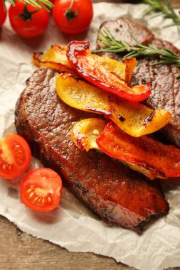 Kompozisyon kağıt sayfası, domates ve biberiye dal ahşap zemin üzerine kavrulmuş lezzetli etli