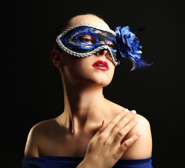 Süslü glitter makyaj ve koyu arka plan üzerinde maskeli balo maskesi ile güzel bir kadın portresi