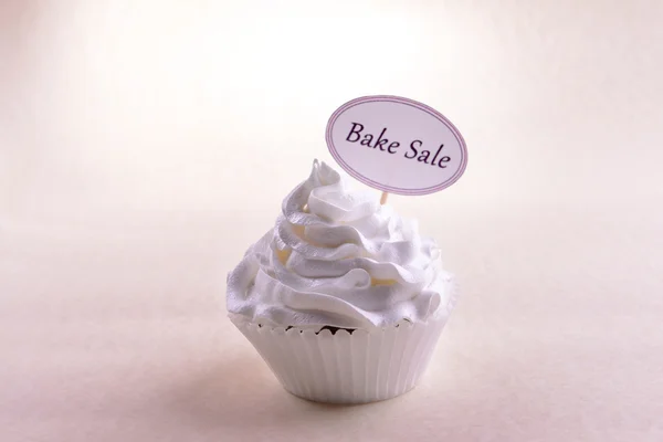 Delicious cupcake with inscription on table on beige background — Stock Photo, Image