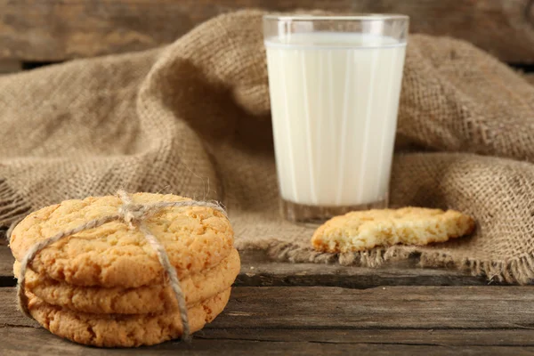 Tasty cookies and glass of milk on rustic wooden background — Stock Photo, Image