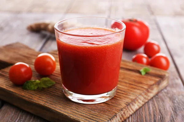 Szklankę soku pomidorowego z pomidorkami na drewnianym stole z bliska — Zdjęcie stockowe