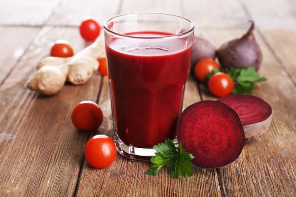 Copo de suco de beterraba com legumes na mesa de madeira close-up — Fotografia de Stock