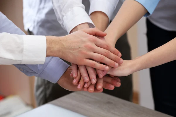 United hands of business team on workspace background