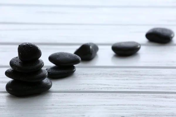 Pedras de spa com gotas de água no fundo de madeira — Fotografia de Stock