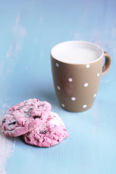 Różowy cookies i kubek z mleka na stół szczegół — Zdjęcie stockowe