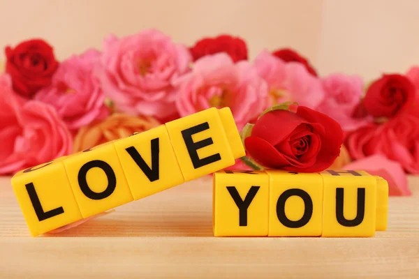 Woorden Love You gevormd uit kubussen met bloemen op lichte achtergrond — Stockfoto