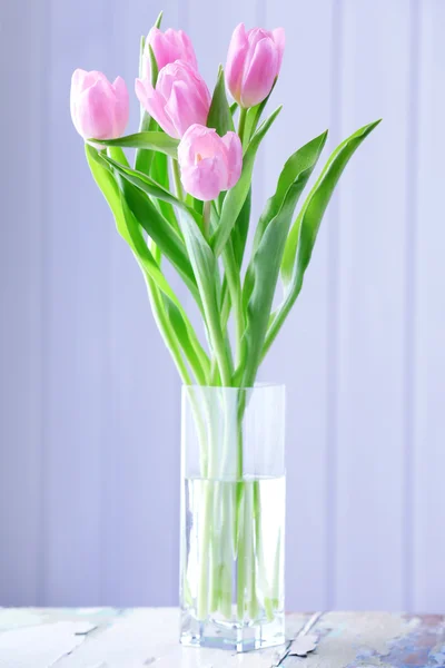 Beautiful pink tulips in vase on table on wooden background — Stock Photo, Image