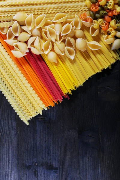 Different types of pasta on wooden table background — Stock Photo, Image