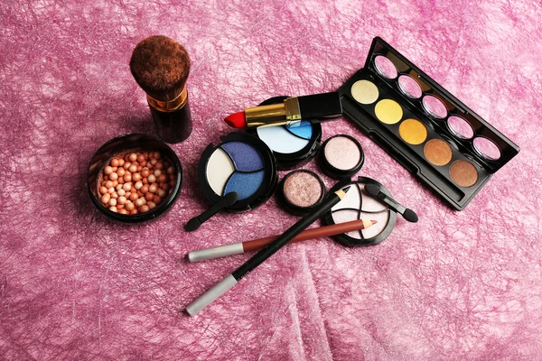 Set di cosmetici colorati su sfondo rosa testurizzato — Foto Stock