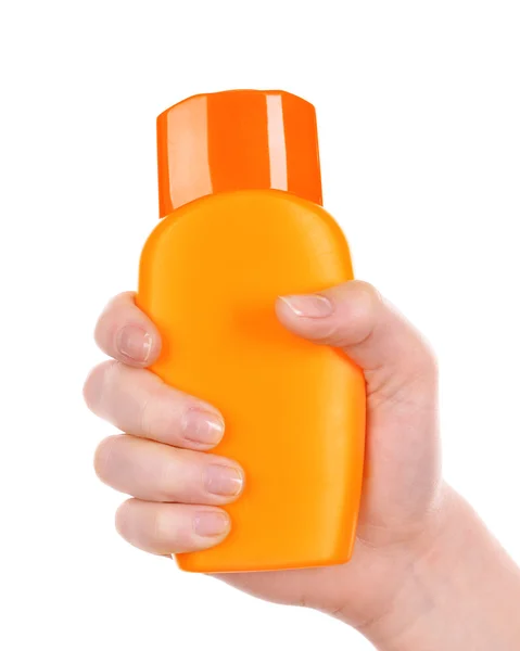 Botella de crema bronceadora en mano femenina aislada sobre blanco — Foto de Stock