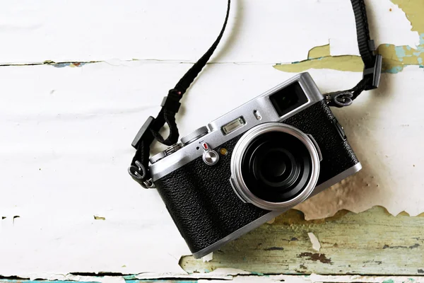 Ретро-камера на деревянном фоне старого цвета — стоковое фото