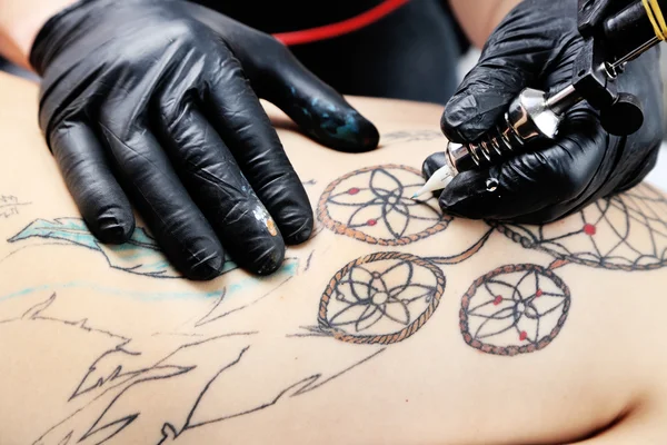 Tattooer showing process of making tattoo, close up — Stock Photo, Image