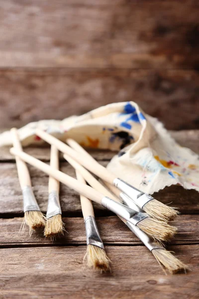 Paint brushes on old wooden background — Stock Photo, Image