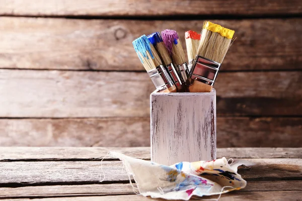 Pinceles con pinturas de colores sobre fondo de madera viejo —  Fotos de Stock