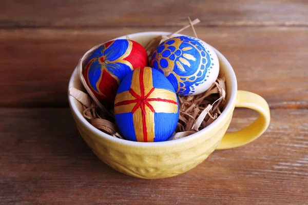 Easter eggs in mug on wooden background — Stock Photo, Image