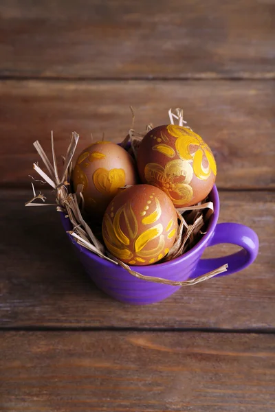 Huevos de Pascua en taza sobre fondo de madera — Foto de Stock