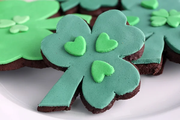 Galletas en forma de cuatro hojas de trébol para el día de San Patricio en el plato de cerca —  Fotos de Stock