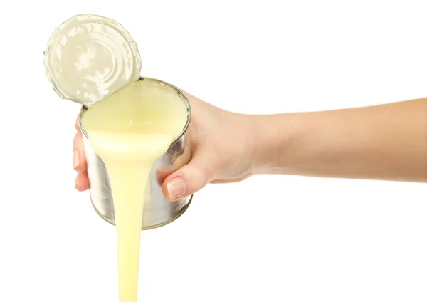 Mão feminina segurando lata de leite condensado isolado em branco — Fotografia de Stock