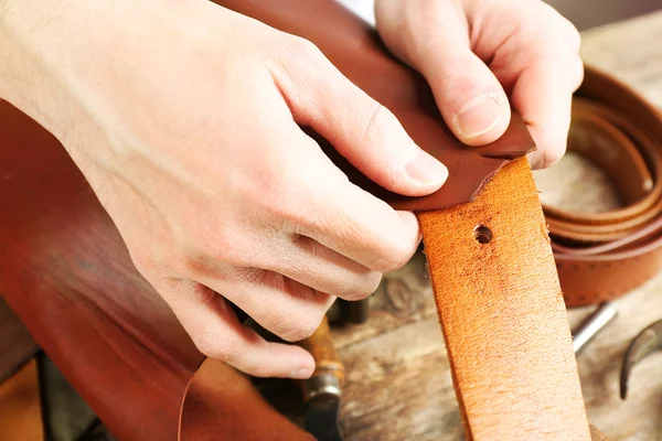 Repairing leather belt in workshop — Stock Photo, Image