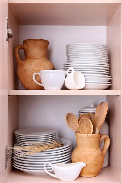 Utensilios de cocina y vajilla en estantes de madera —  Fotos de Stock