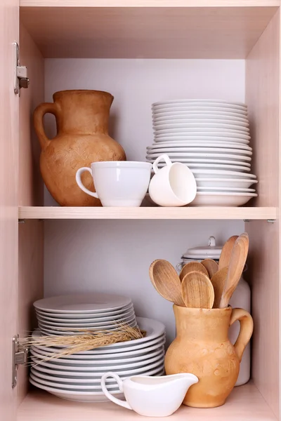 Kitchen utensils and tableware on wooden shelves