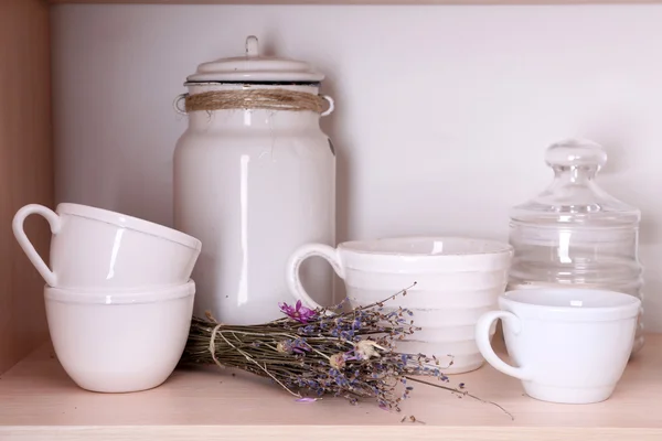 Kitchen utensils and tableware on wooden shelf — Stock Photo, Image