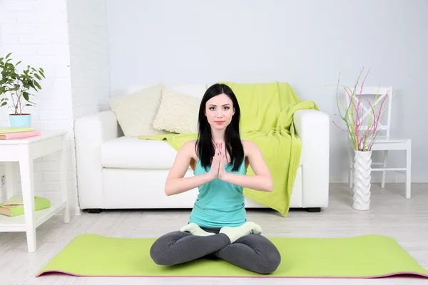 Ung kvinna som gör yoga hemma — Stockfoto
