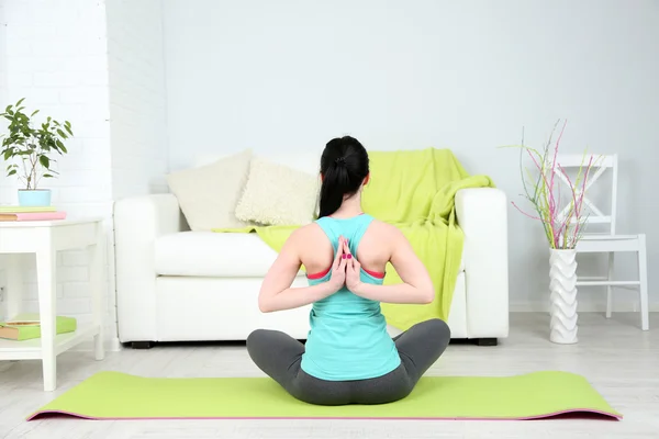 Giovane donna che fa yoga a casa — Foto Stock