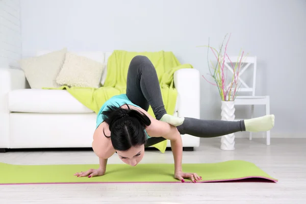 Giovane donna che fa yoga a casa — Foto Stock