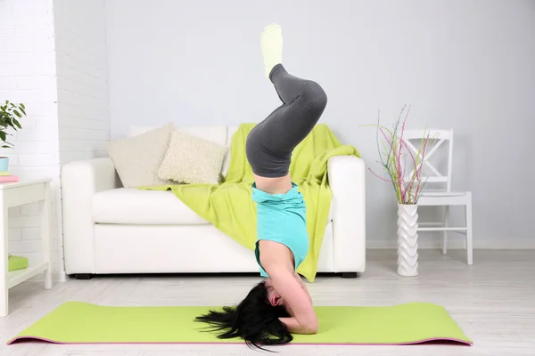 Ung kvinna som gör yoga hemma — Stockfoto