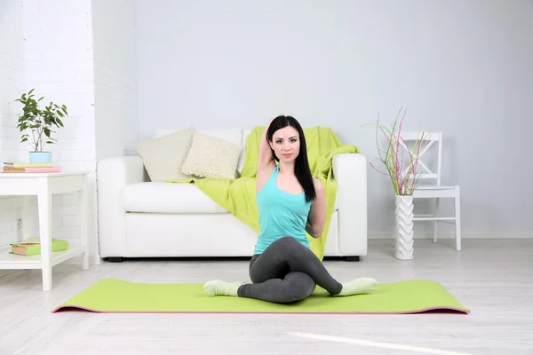 Mujer joven haciendo yoga en casa —  Fotos de Stock