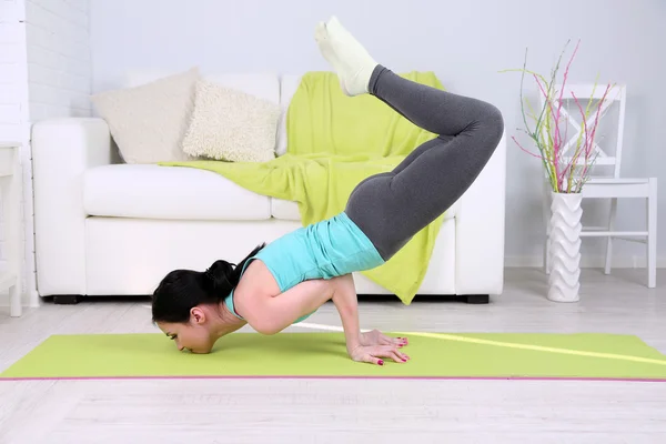 Mujer joven haciendo yoga en casa —  Fotos de Stock