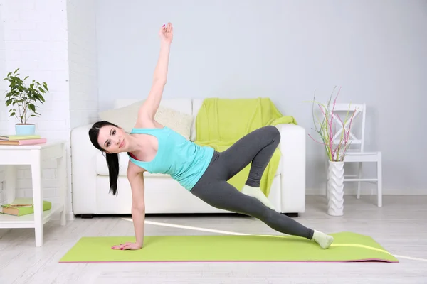 Mujer joven haciendo yoga en casa —  Fotos de Stock