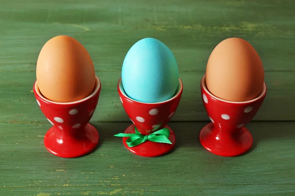 Gekookte eieren in houders op een houten achtergrond kleur — Stockfoto