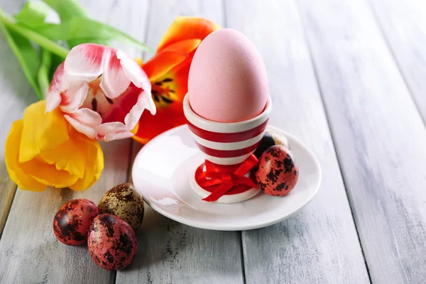 Easter egg in houder en tulp bloemen op houten achtergrond — Stockfoto