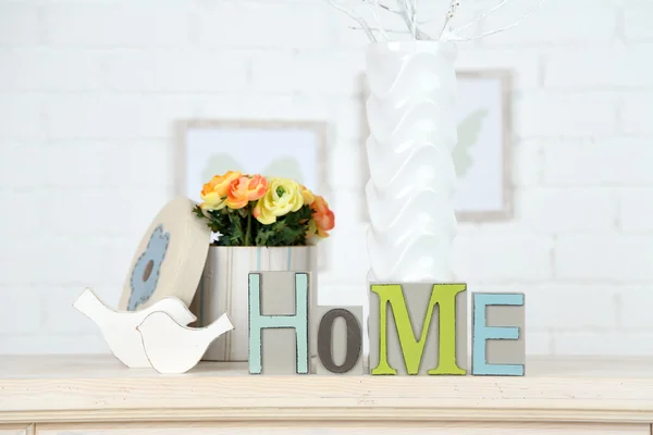 Home in colorful letters, in light white interior, on wooden shelf — Stock Photo, Image