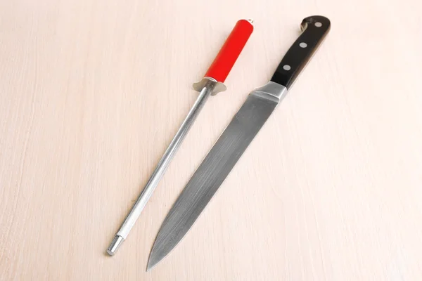 Kniv med Bryne på trä bakgrund — Stockfoto