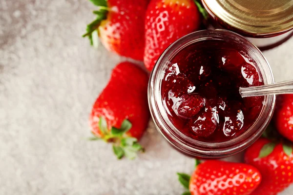 Gläser Erdbeermarmelade mit Beeren auf Tablett in Großaufnahme — Stockfoto