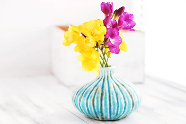 Colorful beautiful freesias on wooden windowsill — Stock Photo, Image