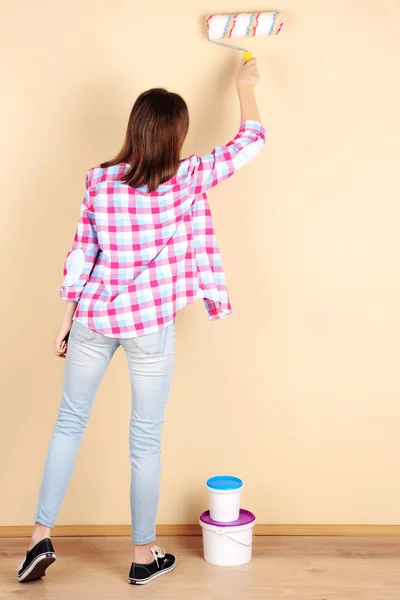 Schöne Frau bemalt Wand im Zimmer — Stockfoto